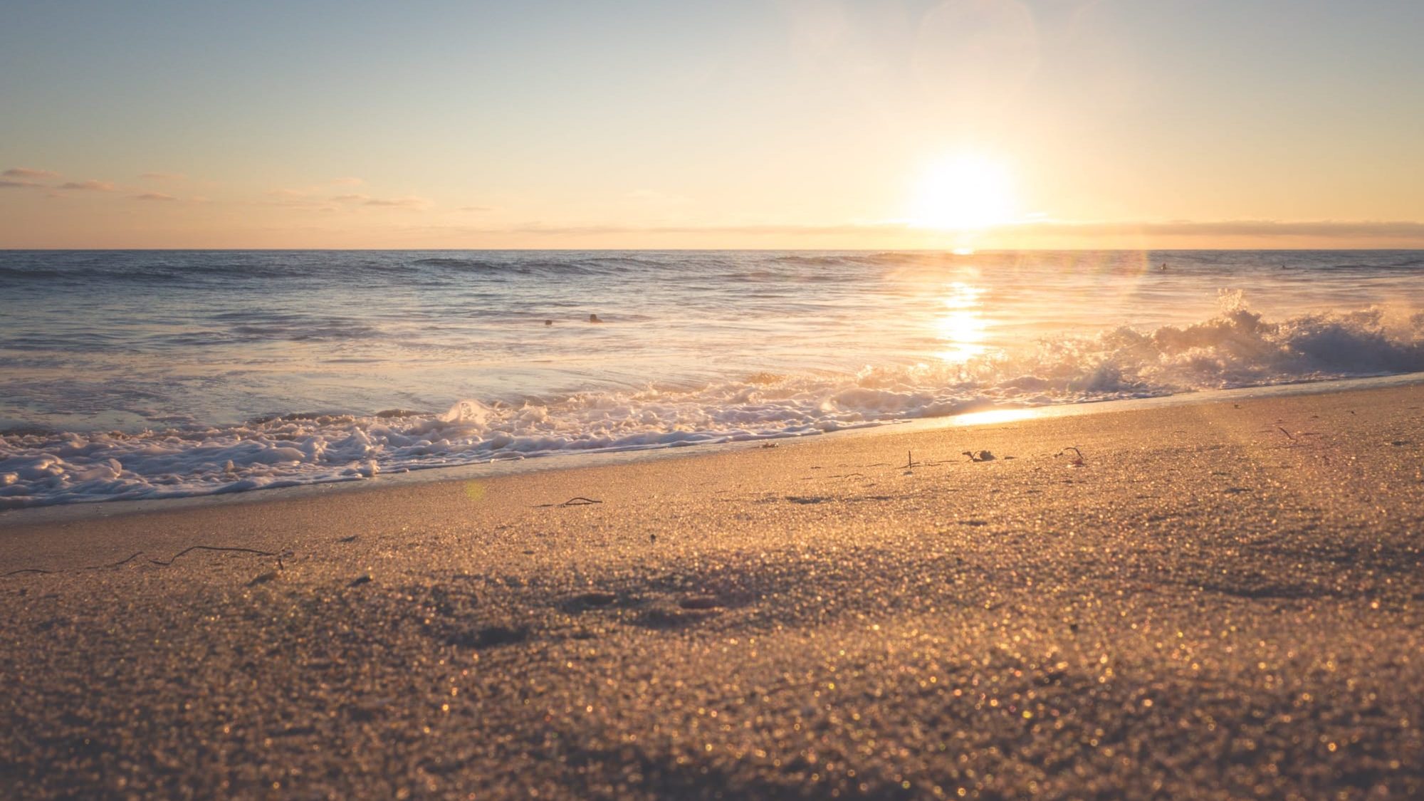 The sun setting over the sea, seen from the water's edge